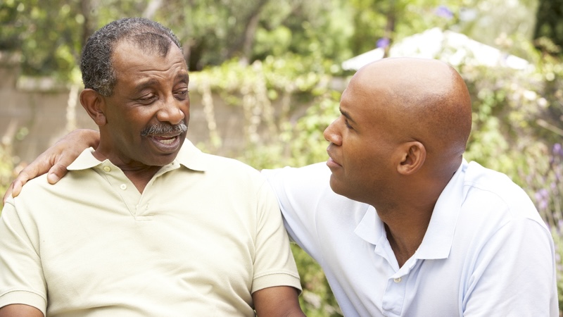 A father and adult son chatting outside, for article on a son frustrated with his dad and silly questions. Image by Monkey Business Images.