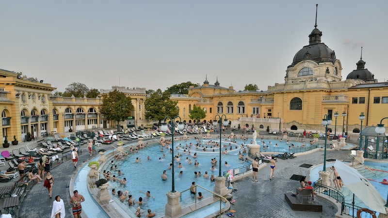 Budapest’s Széchenyi Baths has stunning outdoor facilities — and hosts locals of all shapes and sizes squeezed into tiny swimsuits. CREDIT: Cameron Hewitt, Rick Steves’ Europe.. Take a dip in the spas of Europe, for an enjoyable time, warm acceptance, and a great story to tell. Travel pro Rick Steves transports us there.