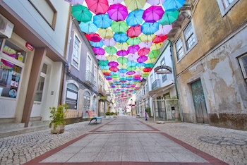 Colorful umbrellas in the street during the Agitágueda street festival in the Portuguese town of Agueda.