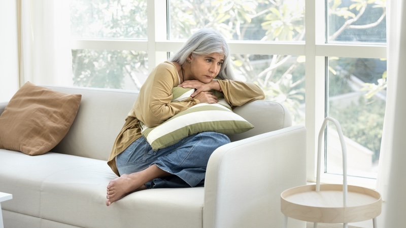 a sad woman sits alone, dealing with her hidden grief. Fizkes
