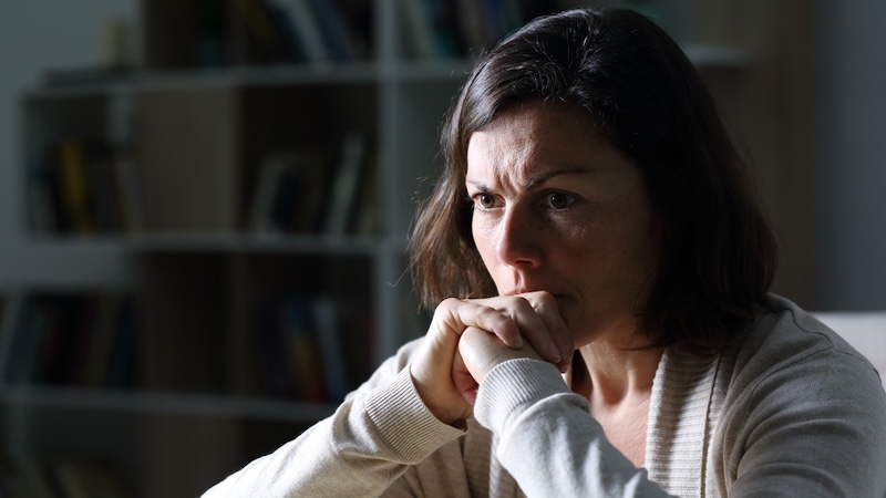 An anxious woman at home in the dark, managing anxiety disorder.
