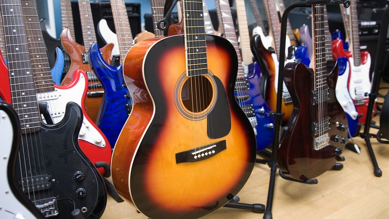 An assortment of guitars in a store. Valeriy Velikov. Are boomer boys, now men, more alike or more different?