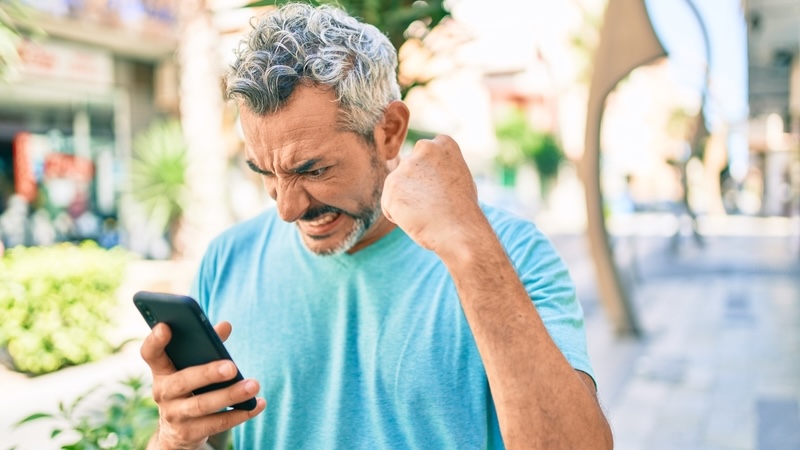 Angry man on his phone trying to fight the annoyance economy. Aaron Amat
