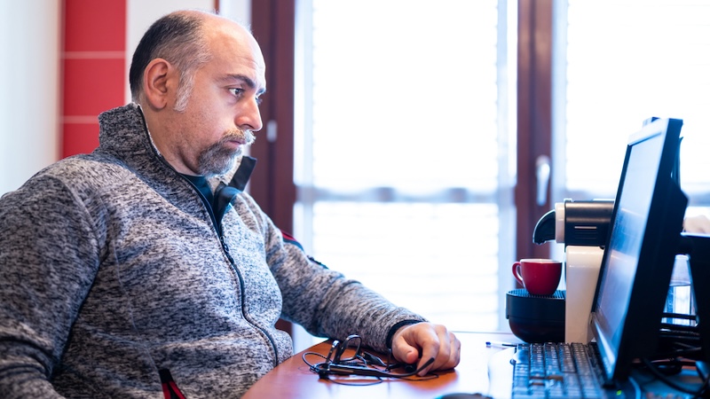 A man at his computer is unhappy at work but nervous for the second act. Massimo Parisi.