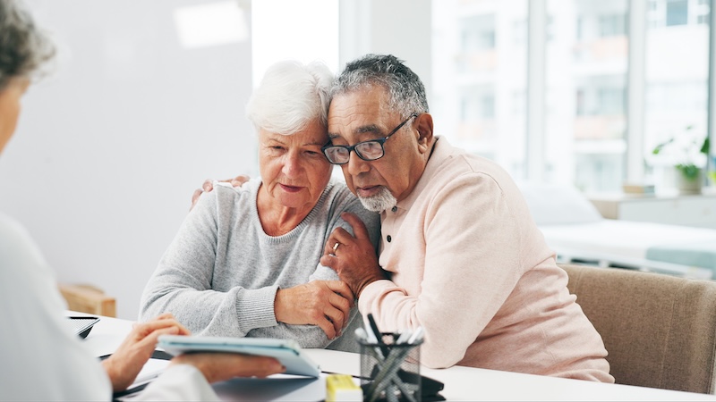 A concerned couple in the doctors office, facing a new diagnosis in their years of Medicare. Yuri Arcurs