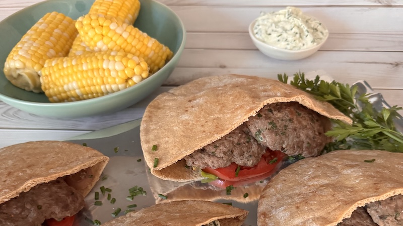 Lamb burgers and corn on the cob with creamy feta