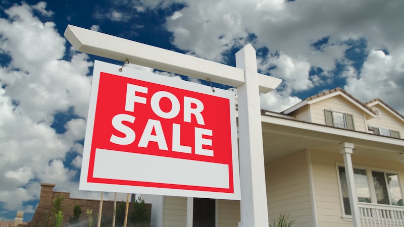 For Sale sign in front of a house. Manage your parent's home sale with these tips. Feverpitched